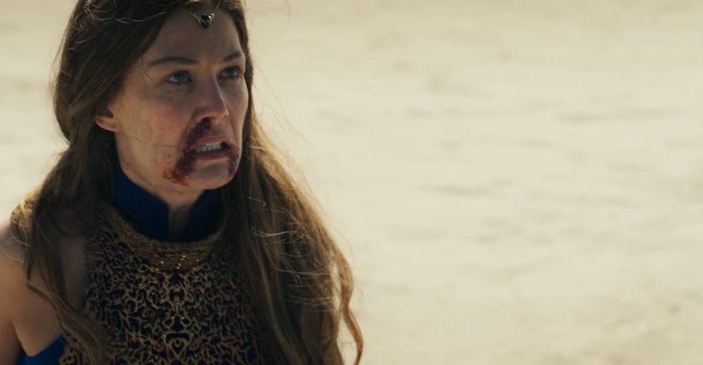 Moiraine with a bloodied nose and mouth looking at Lanfear with anger. 