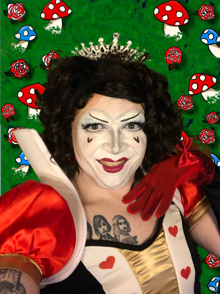 Kitten Tiramisu dressed as the Queen of Hearts, with a white face of makeup and angry eyebrows