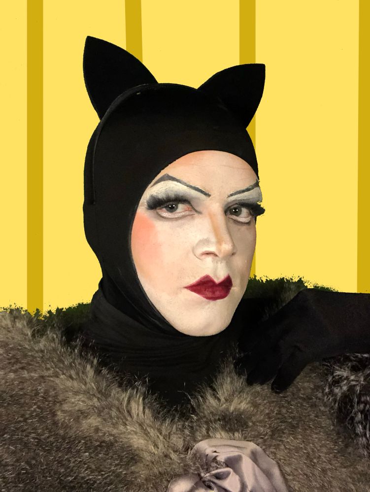 Kitten it a black cat costume with a gray fur shawl