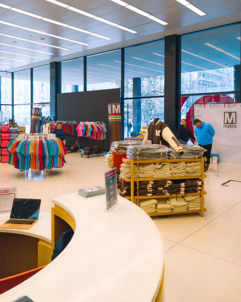 wide shot of a wmata/metro holiday pop up store inside a library setting.