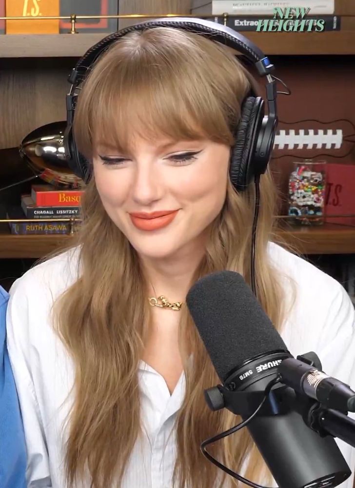 taylor swift being amused and looking down with a smile 