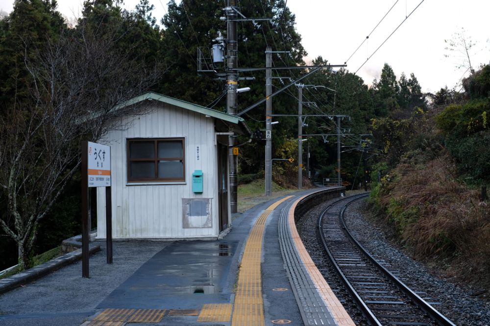 小さな駅舎と緩いカーブのホーム(辰野方)