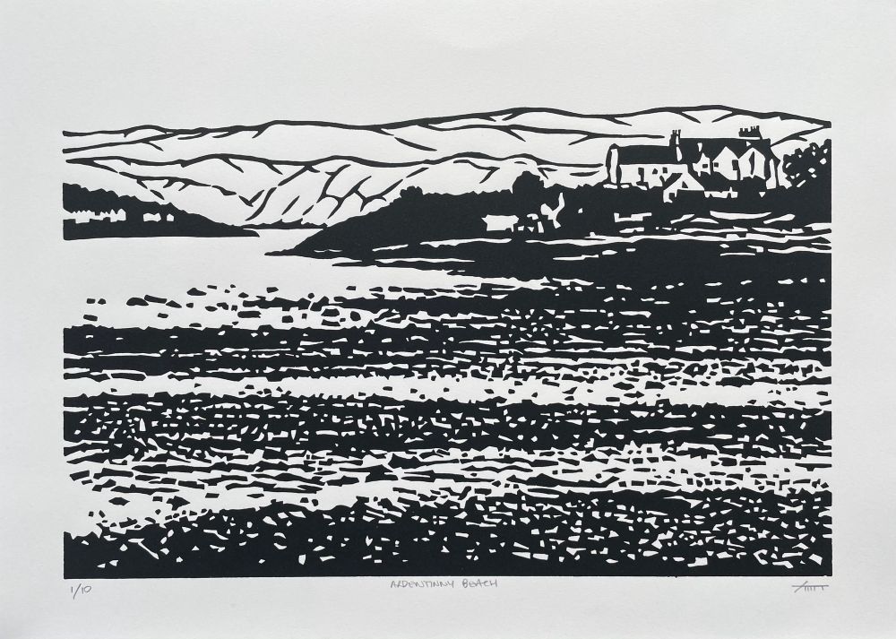 Black & white print of a beach at low tide with hills in the distance. It is the key block from the colour image. 