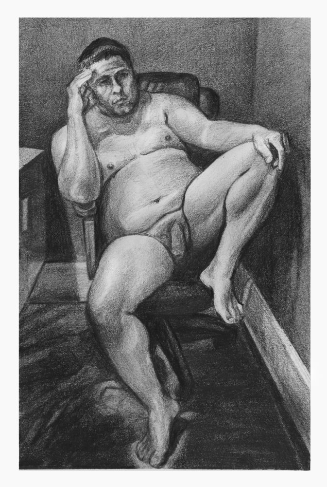 Black and white. Sitting male with a pensive expression