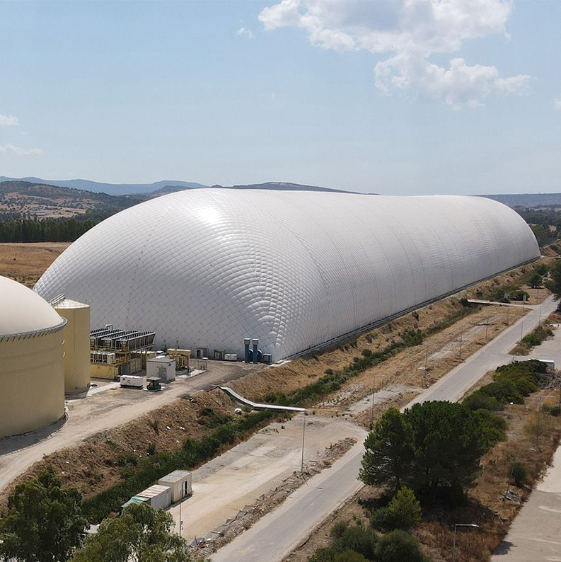 A huge white rectangular inflated structure set against mountains in the background. It is a CO2 battery that can store energy over long durations.
