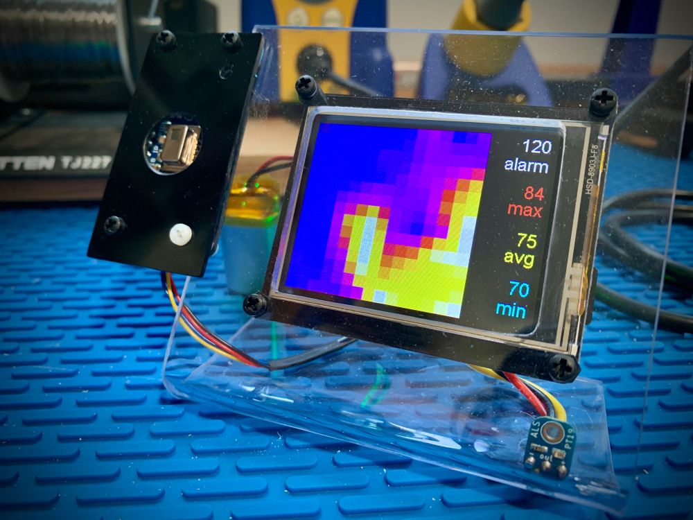 The workshop thermal camera prototype's 2.4" TFT display showing a pseudo-color image from the thermal camera attached to the left of the display. The display also indicates the maximum, minimum, and average temperatures in the image as well as the alarm temperature.