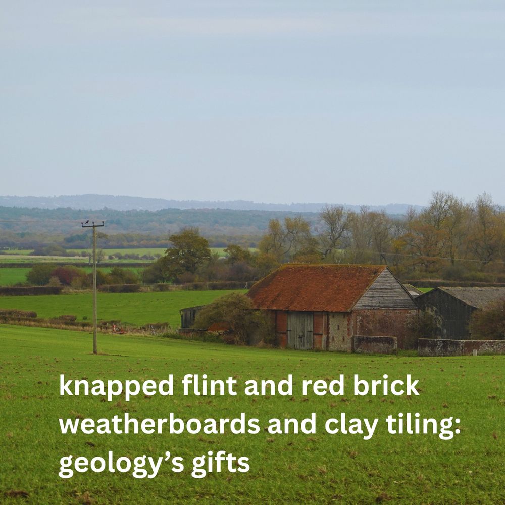 Photo shows a low farm building with an orange roof. It has silvery-grey stone walls partly covered in timber. The colours match the surrounding countryside.  The poem reads ~ knapped flint and red brick, weatherboards and clay tiling:/ geology’s gifts