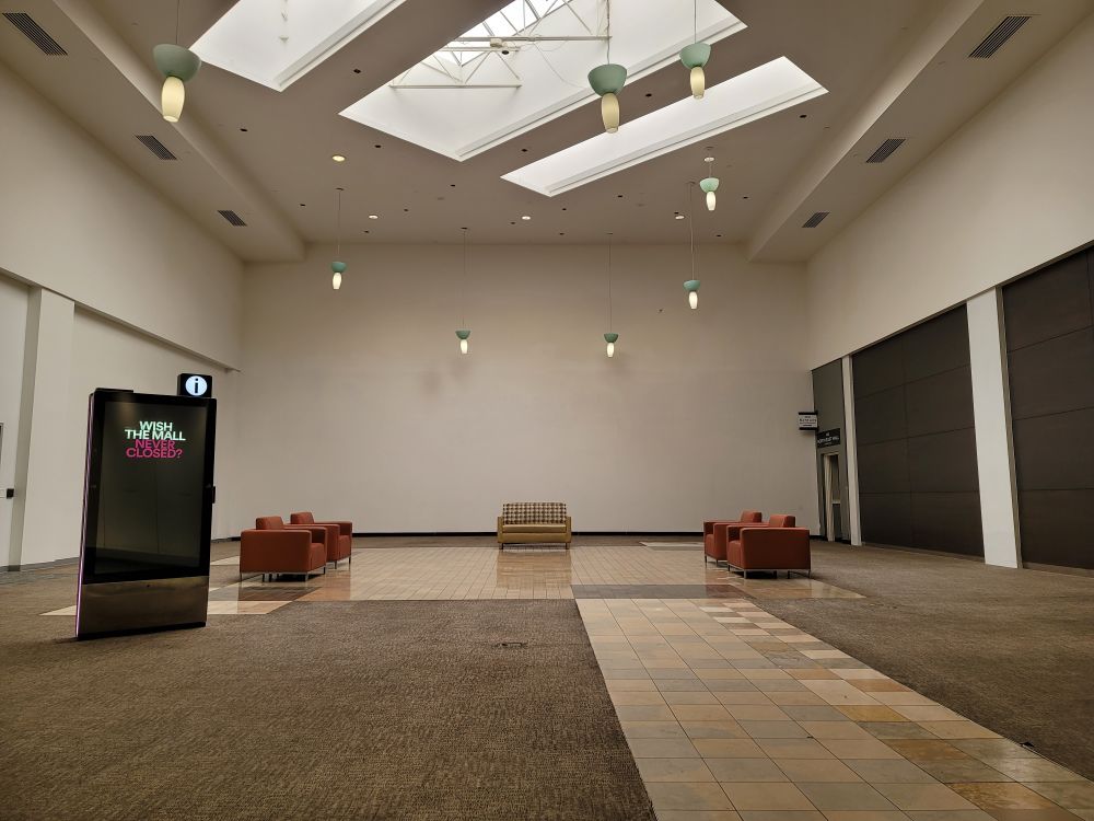 An empty space at my local mall. The text on the sign to the left reads "wished the mall never closed?"