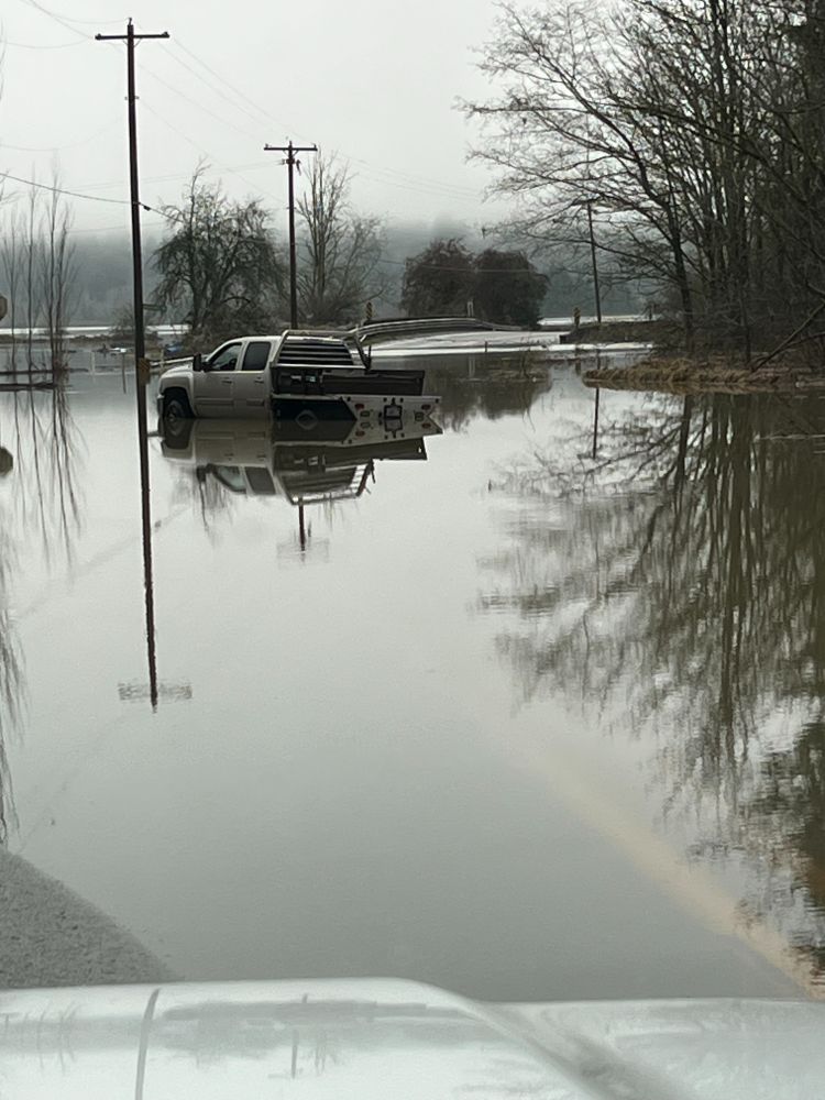 A utility truck sits in a pool of water over State Route 203.