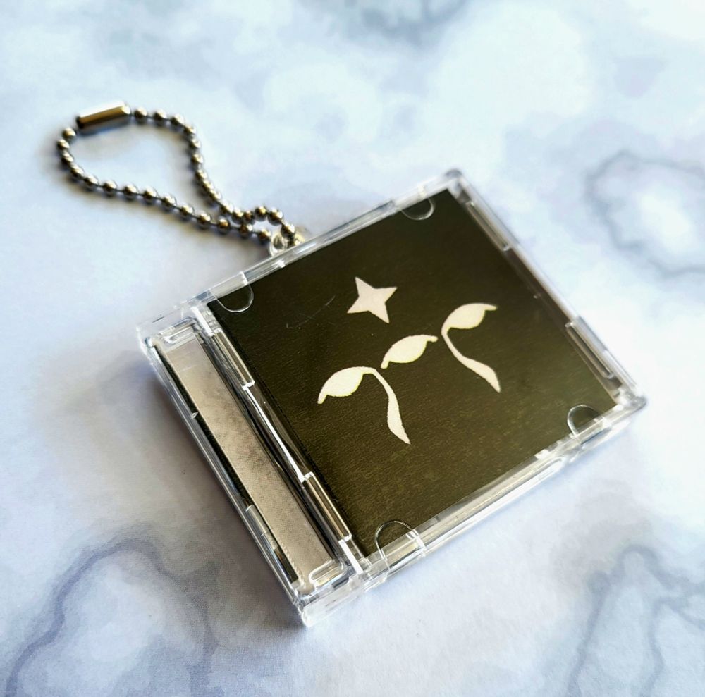 Openable cd charms - front cover is the watchers symbol from drakengard nier. (Black background with three white eyes)