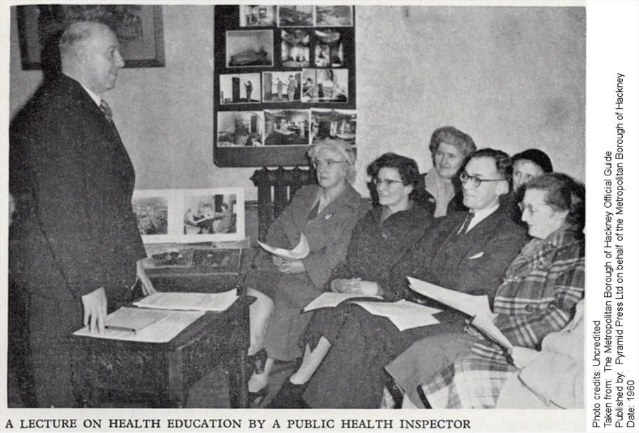 A black and white photo captioned: A LECTURE ON HEALTH EDUCATION BY A PUBLIC HEALTH INSPECTOR

A man stands iin front of a group of seated local residents in a not entirely natural pose.

Photo credits: Uncredited
Taken from: The Metropolitan Borough of Hackney Official Guide
Published by: Pyramid Press Ltd on behalf of the Metropolitan Borough of Hackney
Date: 1960