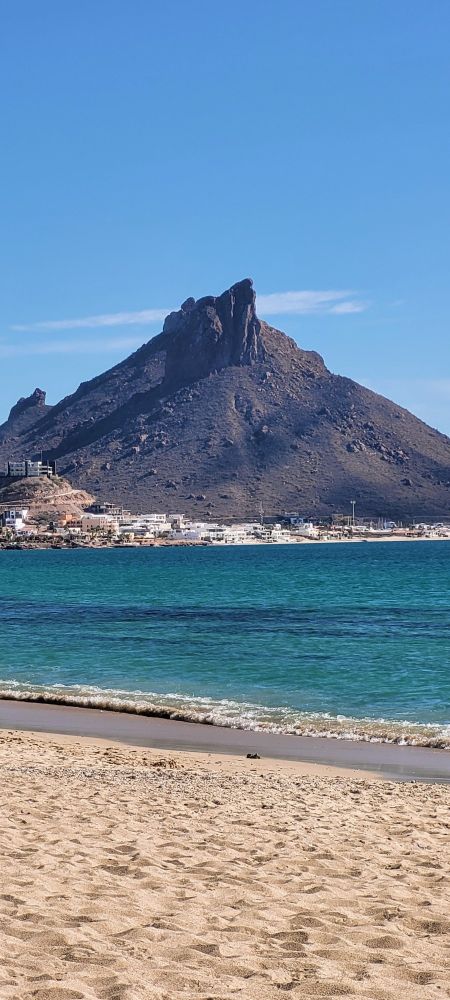 Empty Beach with hill in the background.