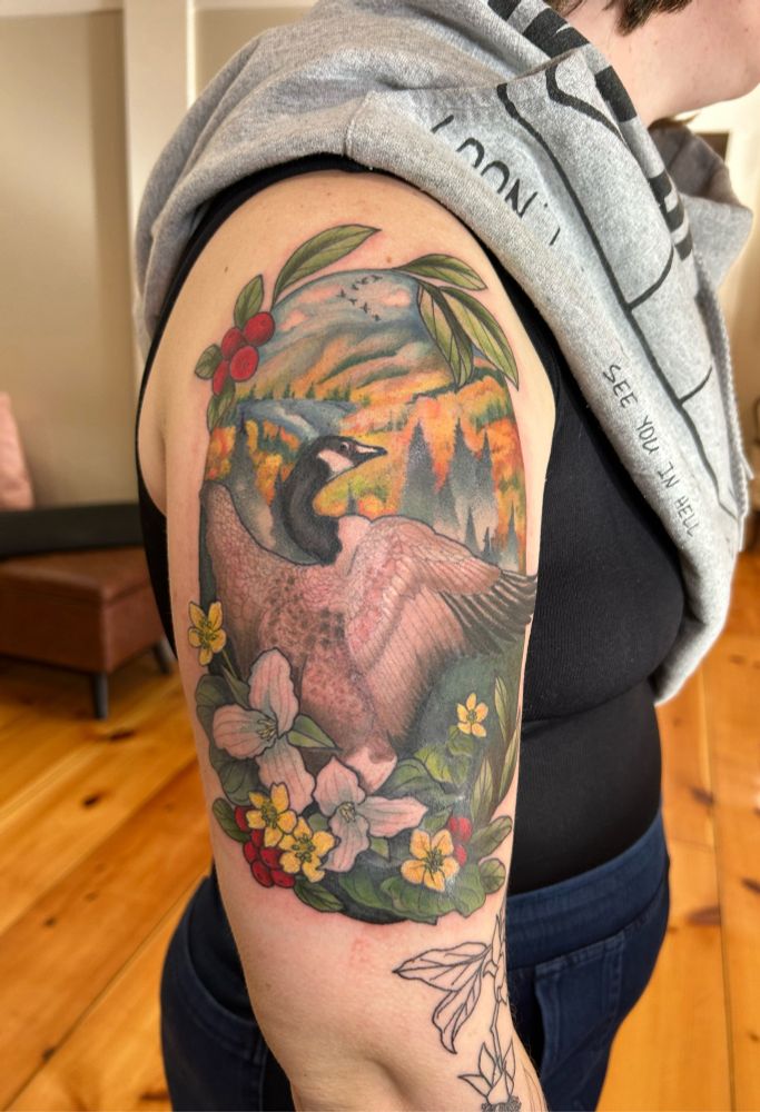 A tattoo of a goose surrounded by native New England flora. 