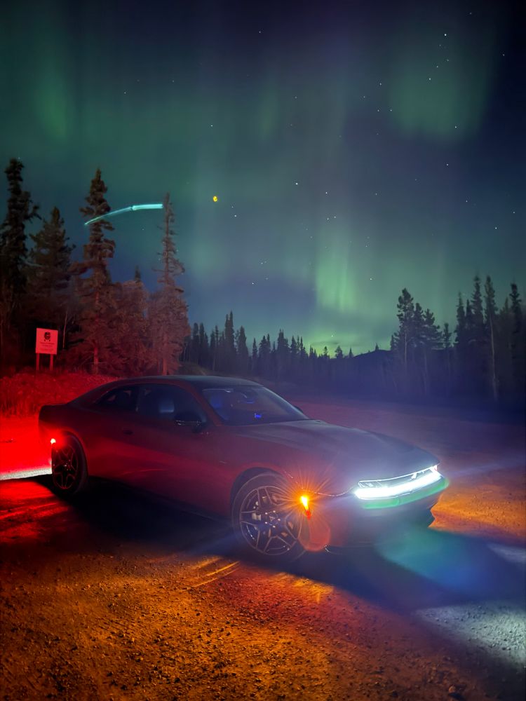 Red Dodge Charger under the Northern Lights outside  Whitehorse Yukon Oct 1 2025