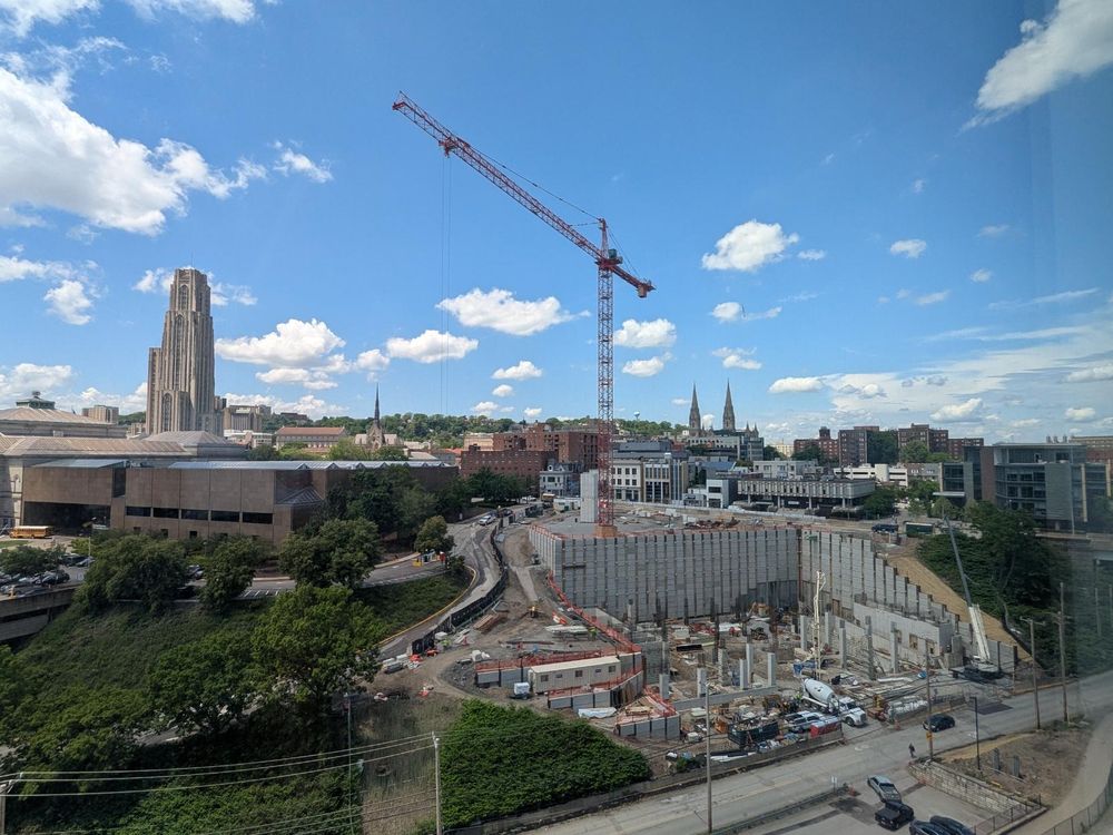 Blue sky and clouds with a very tall crane and a duj