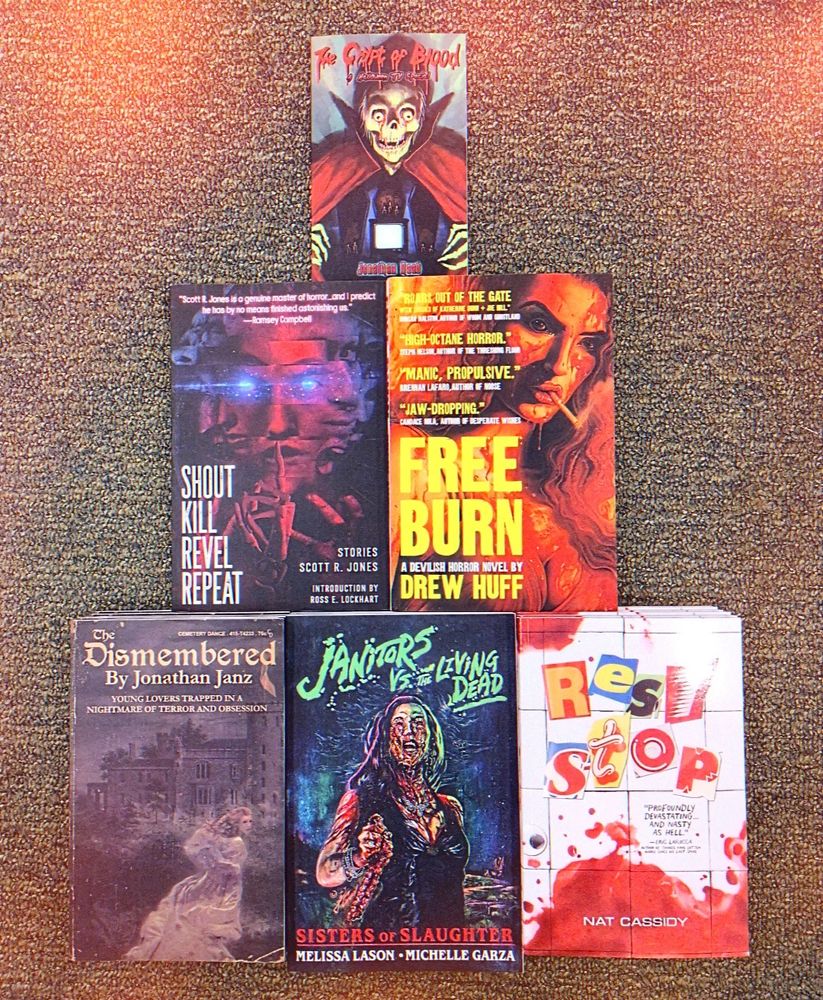 an assortment of horror books on a carpeted floor