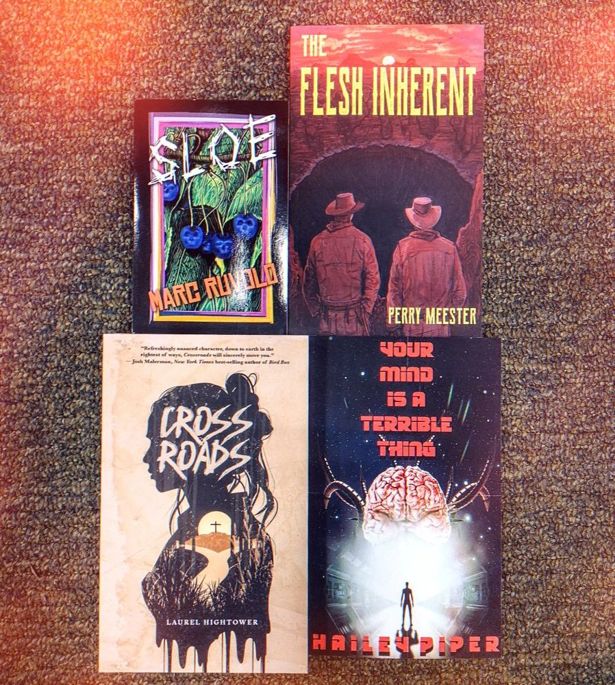 an array of horror books on a carpeted floor