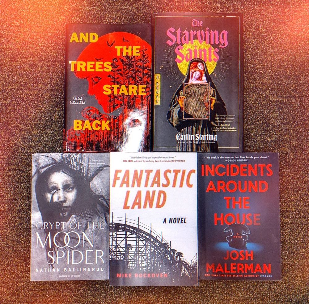 an assortment of horror books spread out on a floor 