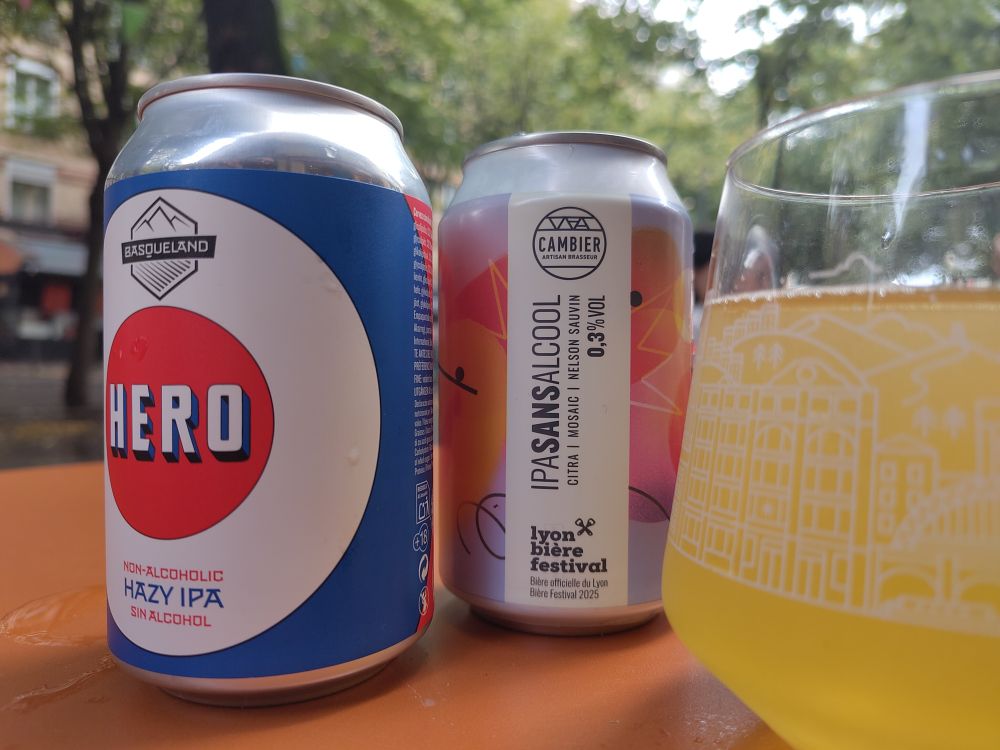 Deux canettes de bière sans alcool sur une table orange en terrasse