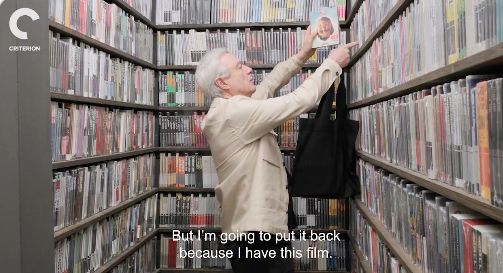 David Byrne in the Criterion Closet putting away a copy of True Stories, saying "But I'm going to put it back because I *have* this film.."