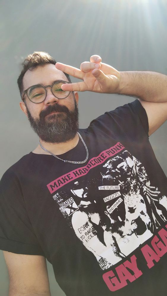 Selfie minha, estou com óculos de grau, barba levemente grisalha camiseta pretacom dizeses "make hardcore punk gay again"