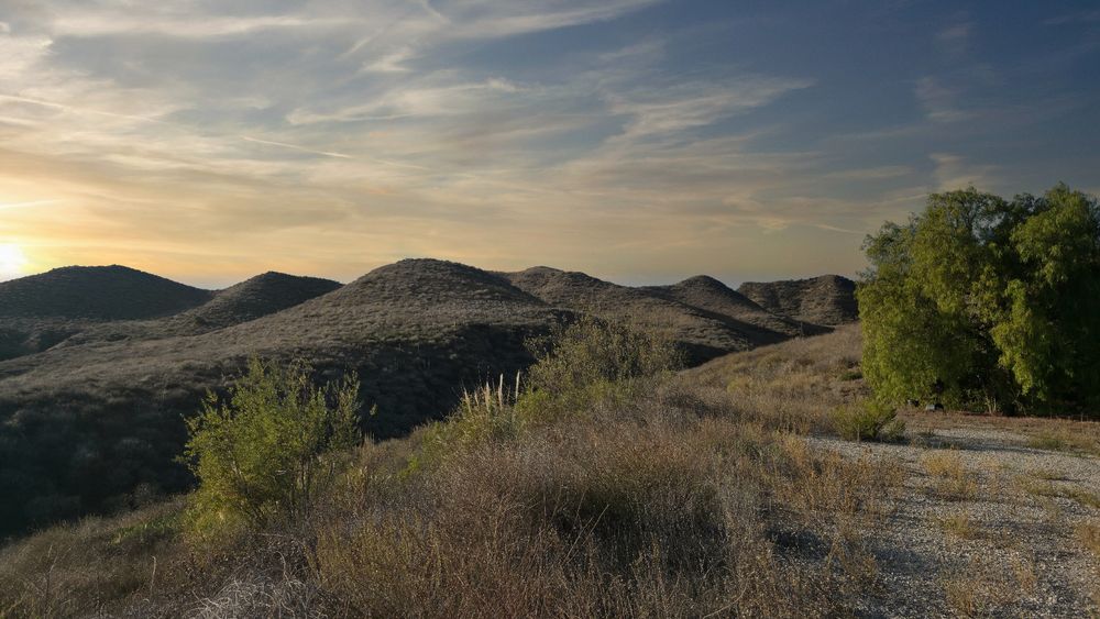 A beautiful fall sunset over open expanse of hills and fields.