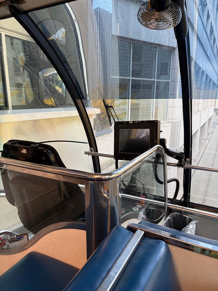 Empty driver’s seat at front of glass windowed monorail. 
