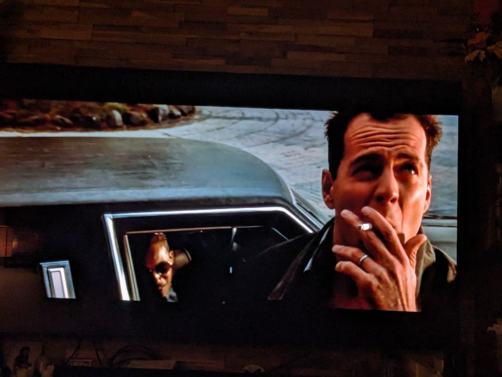 A still scene from the movie "Die Hard." John McClane is exiting a limousine with a cigarette in hand