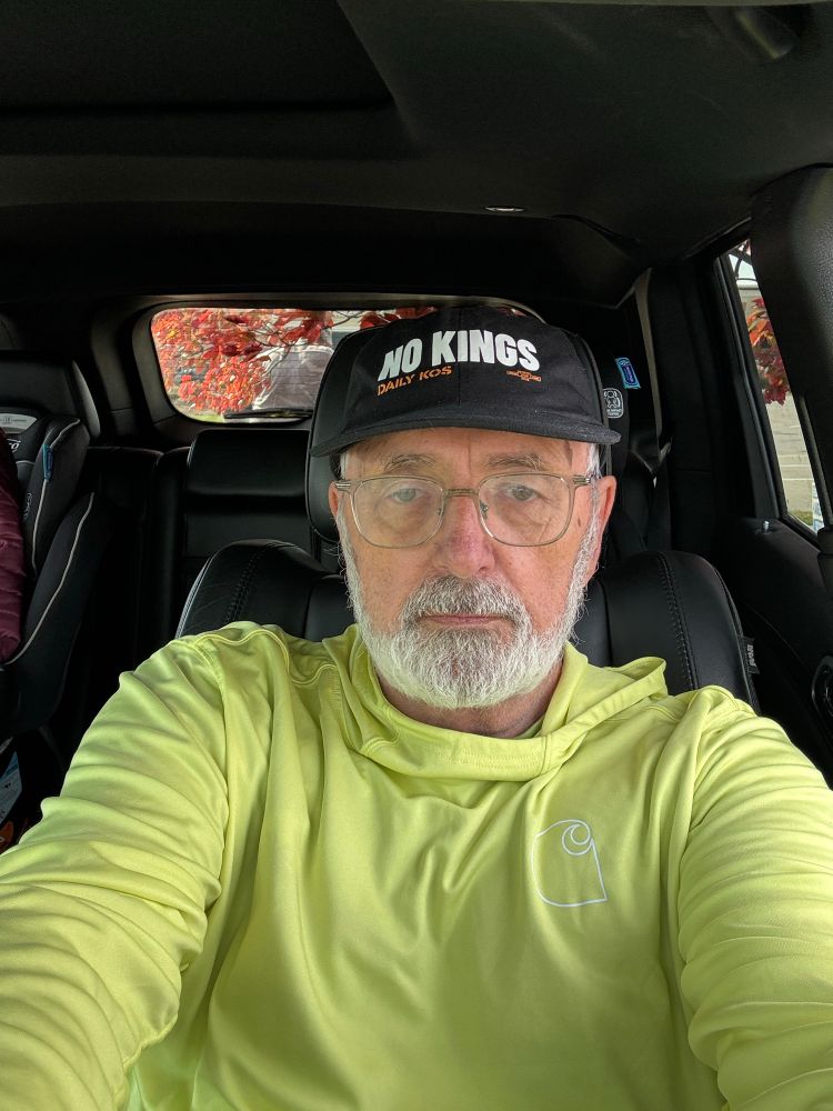 Me in a yellow shirt with a No Kings hat.