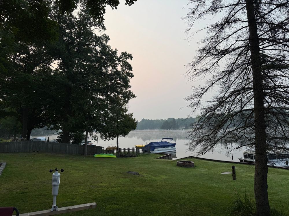 Early morning landscape view of a lake with a reddish tinge to the sky.
