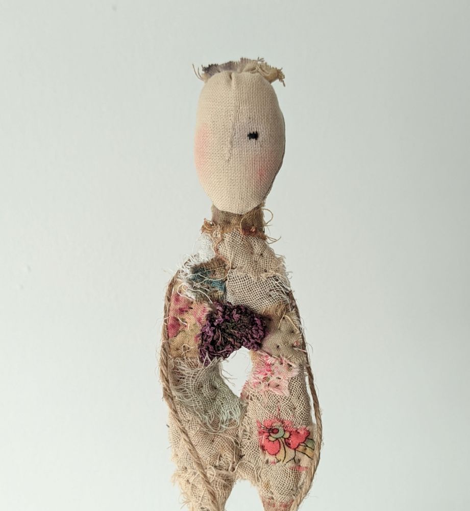A character made of textiles with a hole in its middle. 