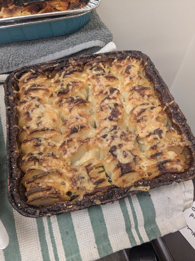 a tray of browned & cream colored roasted crispy potato in a silver foil tray