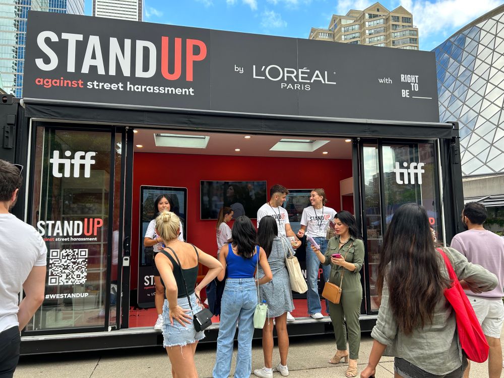 Large, busy kiosk that says Stand Up against Street Harassment