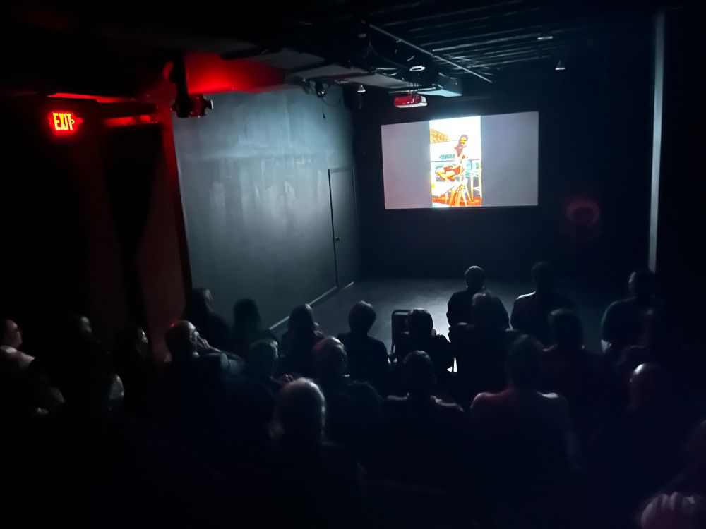 A whole bunch of folks in a theater watching White Meat: Appetizer shot from the back of the audience.