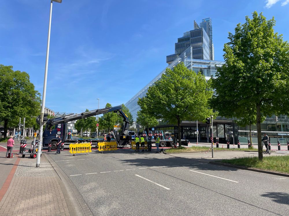 Ein Kran lädt Poller ab als Straßensperre