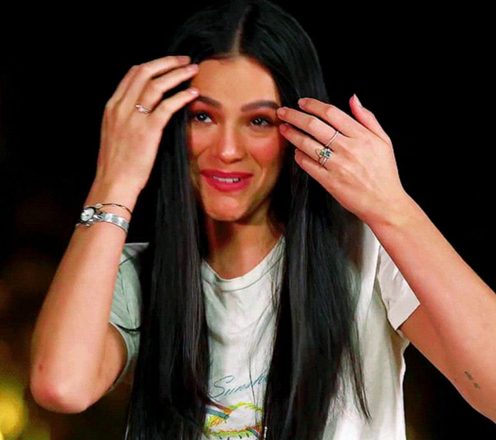 a woman with long black hair is wearing a white shirt with the word sunset on it