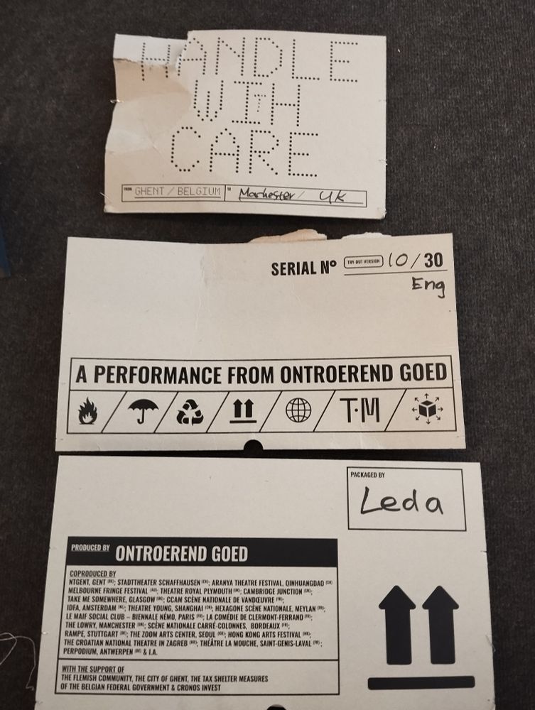 Pieces of a slightly ripped cardboard box, saying 'Handle with Care - A performance from Ontroerend Goed'