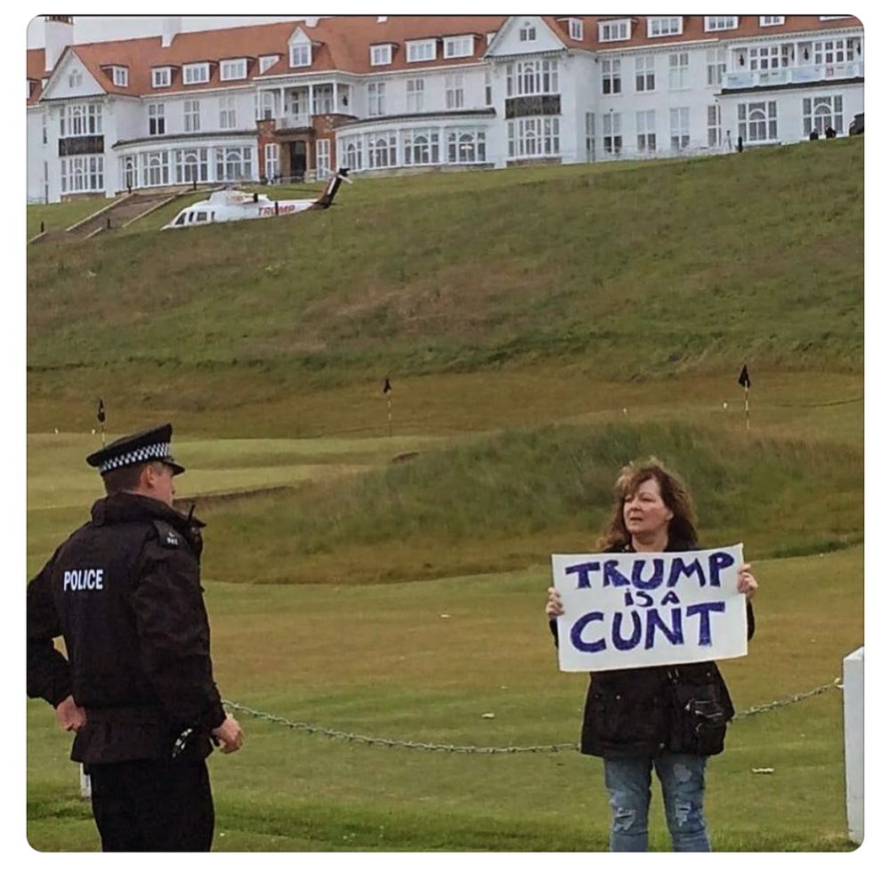 Janey Godley at Turnberry Golf course holding a sign saying Trump is a cunt.