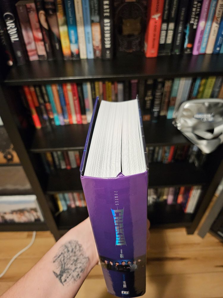 A picture of the spine and top of the novel 7 Fates Chakho. It's quite thick and has a purple ribbon bookmark attached to the spine.