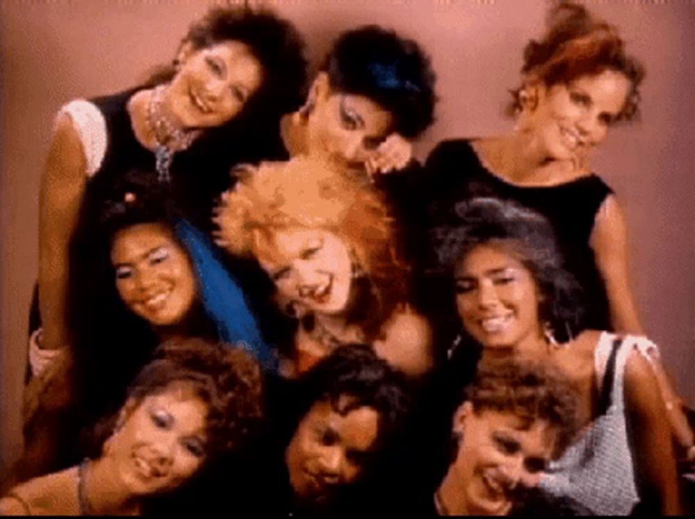 a group of women are posing for a photo and smiling