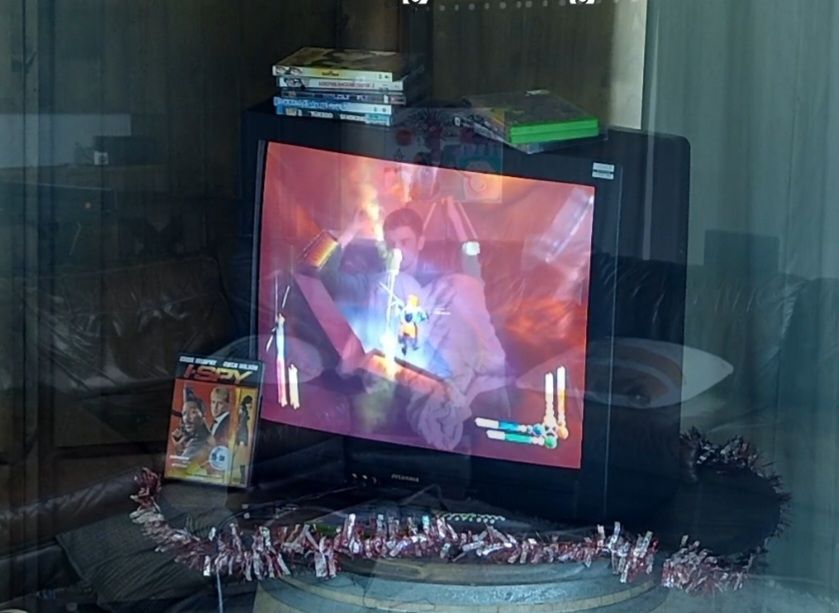 a shot of a CRT playing Azurik: Rise of Perathia, with another shot of streamer MasterGir overlayed at partial opacity, making it look like he's trapped in the TV.