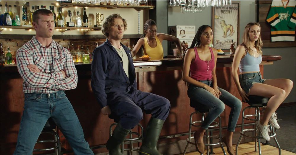 Still from Letterkenny @letterkenny.bsky.social , Gail is tending her bar and 4 other characters seated with their backs to the bar looking at us.  All have stunned/amazed expressions like they're watching a spectacle. 