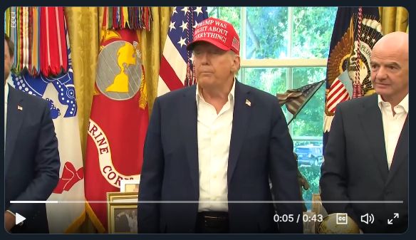 Trump in oval office with stupid MAGA hat on