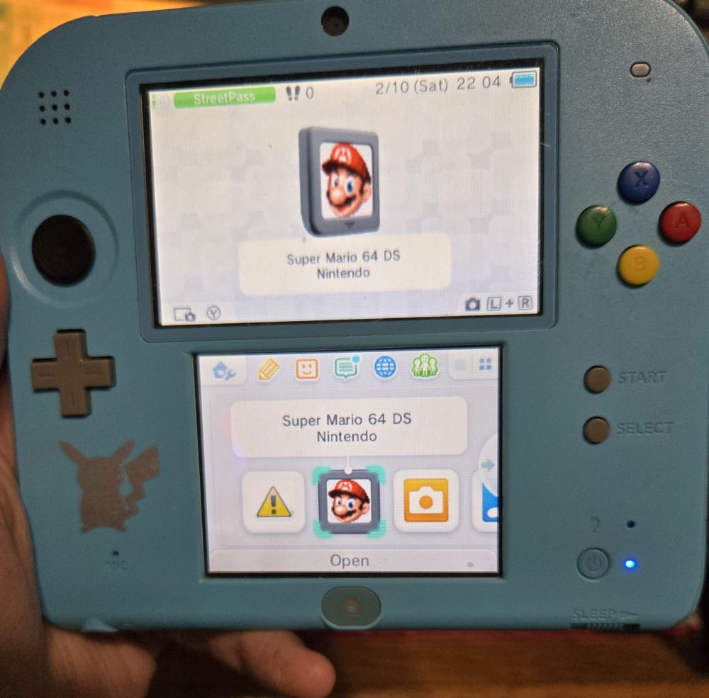 Pictured is a 2DS console with a pikachu symbol on the bottom right.