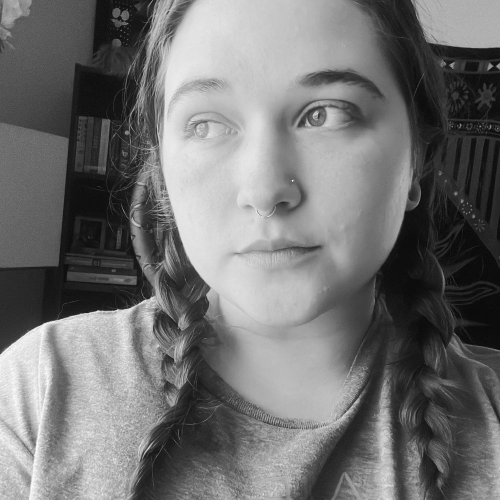 A woman with braids looking away from the camera in black and white