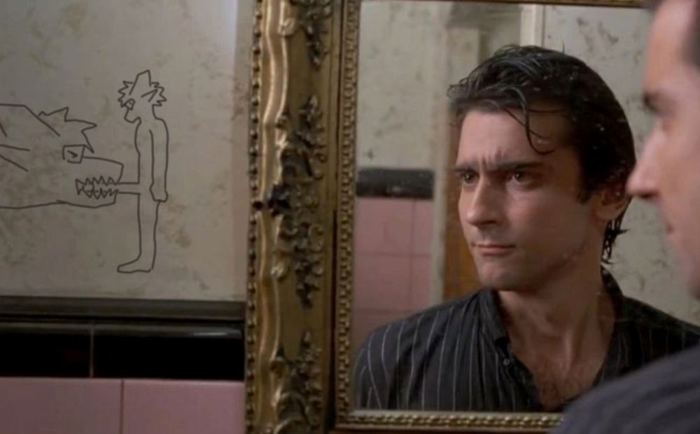 edited screenshot of the scene in which Paul Hackett is looking at graffiti of a shark biting someone's penis, from the film After Hours - both graffiti subjects have been edited to be sharkjet Lex