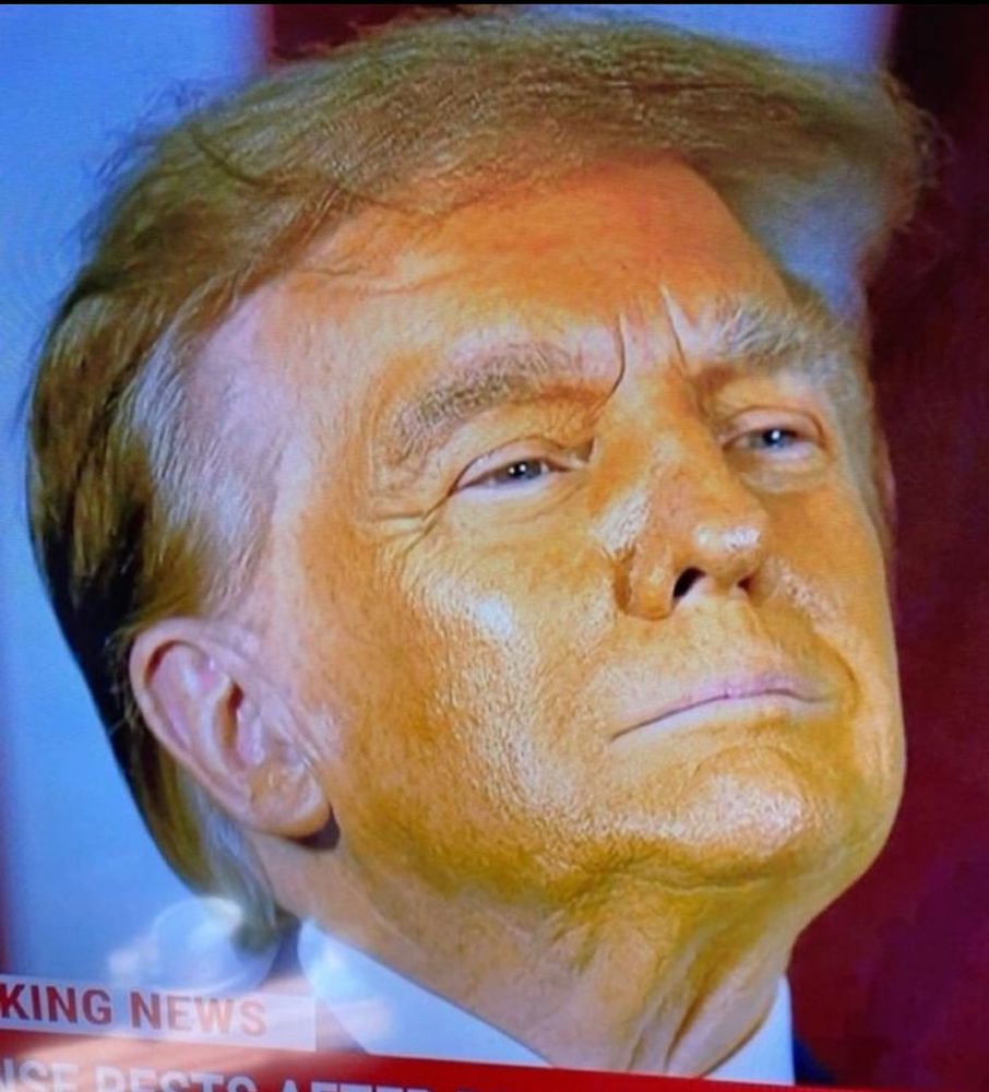Face of Trump, which is very visibly tinted with orange makeup that doesn’t match the rest of his skin