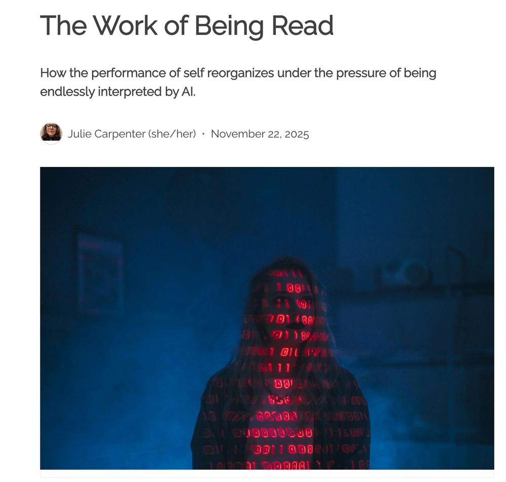 Image with dark blue background and a person's silhouette in shadow with binary code projected in red lights across their body. It says, "The work of being read. How the performance of self reorganizes under the pressure of being endlessly interpreted by AI."