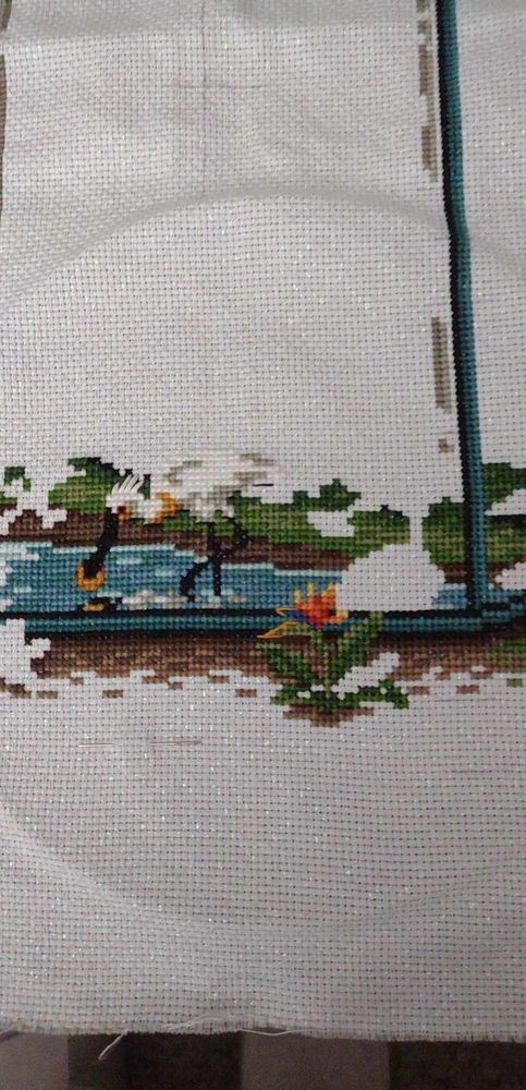 Cross stitch pattern with a bird fishing in water and a Bird of Paradise flower.