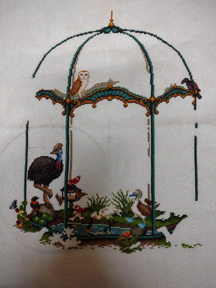 Cross stitch project. An aviary with various birds, including a Barn owl and a Blue Footed Booby.